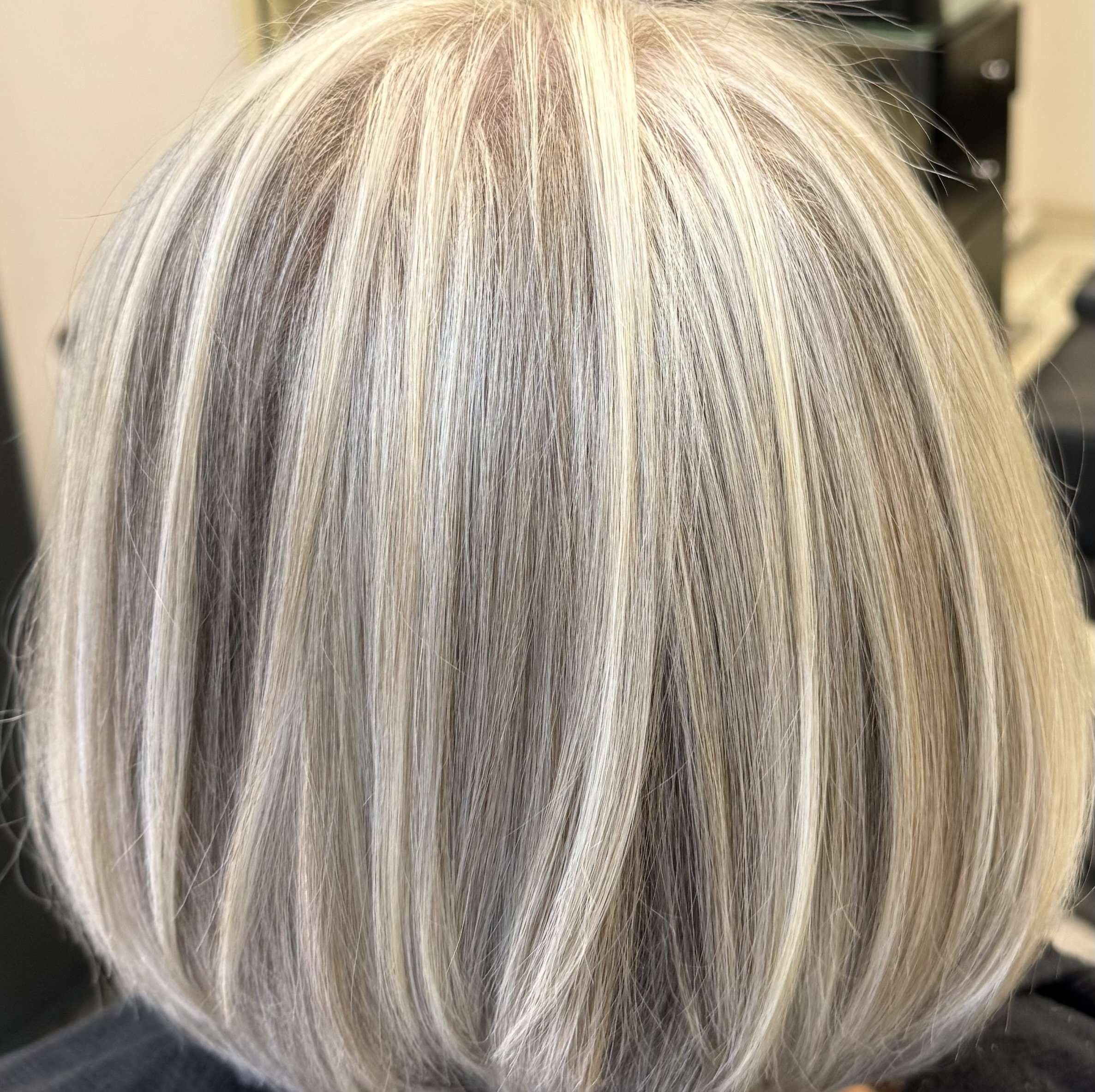 Hinterkopf einer Person mit blond gefärbtem, gestuftem Haar.