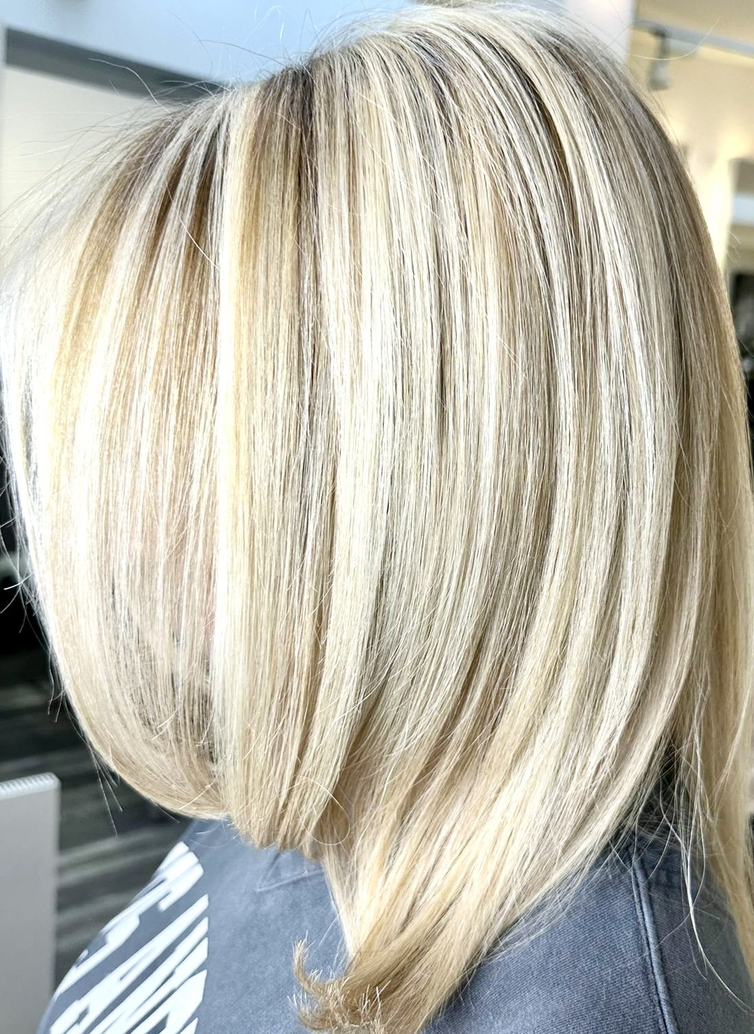 Nahaufnahme glatter, blonder, gestufter Haarstil bei einer Person, aufgenommen aus der Seitenansicht.